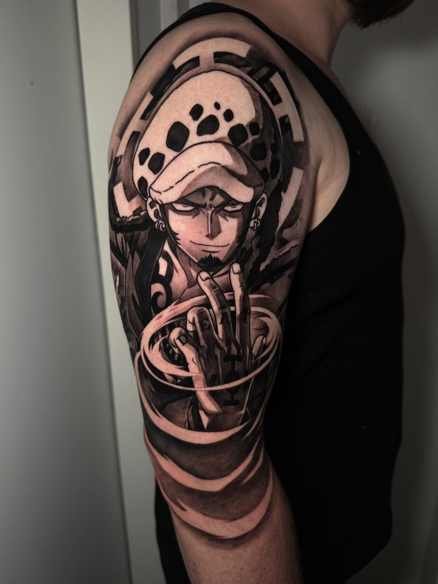 Black and grey anime character upper arm tattoo