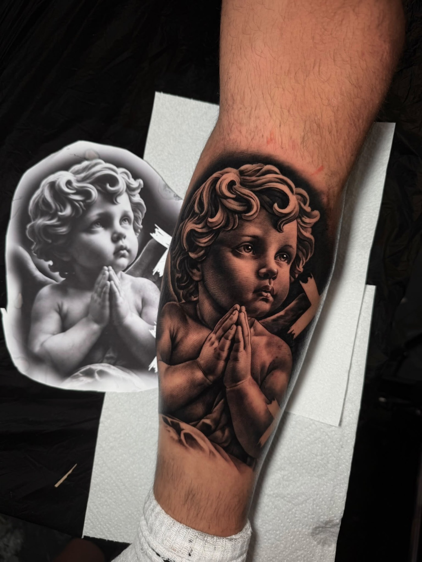 Praying cherub black and grey realism tattoo