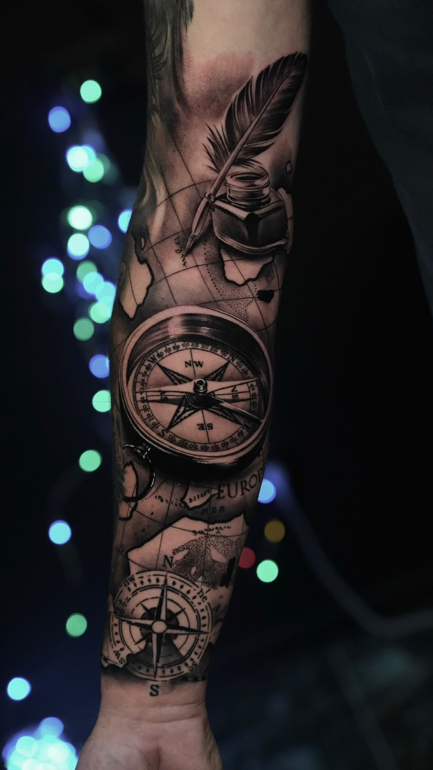 Compass, map and quill forearm tattoo